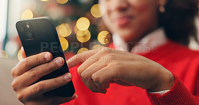 Buy stock photo Christmas, hands and phone with person in living room of home for online shopping or retail. App, browsing and social media with customer at bokeh in apartment to purchase gift or present on mobile
