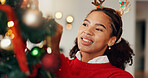 Christmas tree, happy and woman in home with decorations for festive celebration, event or party. Smile, holiday season and female person preparing for xmas with hanging ornaments in apartment.