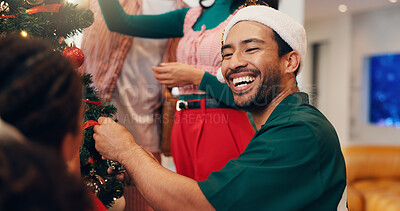 Buy stock photo Christmas, tree and laugh with friends at party for festive season, tradition and decoration. Xmas, holiday cheer and celebration with man in living room of home for happy, help and ornament