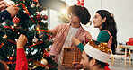 Christmas, ornament and tree with friends in living room of home for celebration or social event. December, decoration and party with group of happy people in apartment together for holiday season