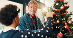 Christmas, home and men with tree, help and bonding together with happiness. People, apartment and friends with smile, Xmas and celebration with tradition, holiday or festive season with decoration