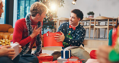 Buy stock photo Christmas, present and smile with friends at party for love, festive holiday and reunion. Gift giving, support and xmas season with people in living room of home for box, secret Santa or celebrate
