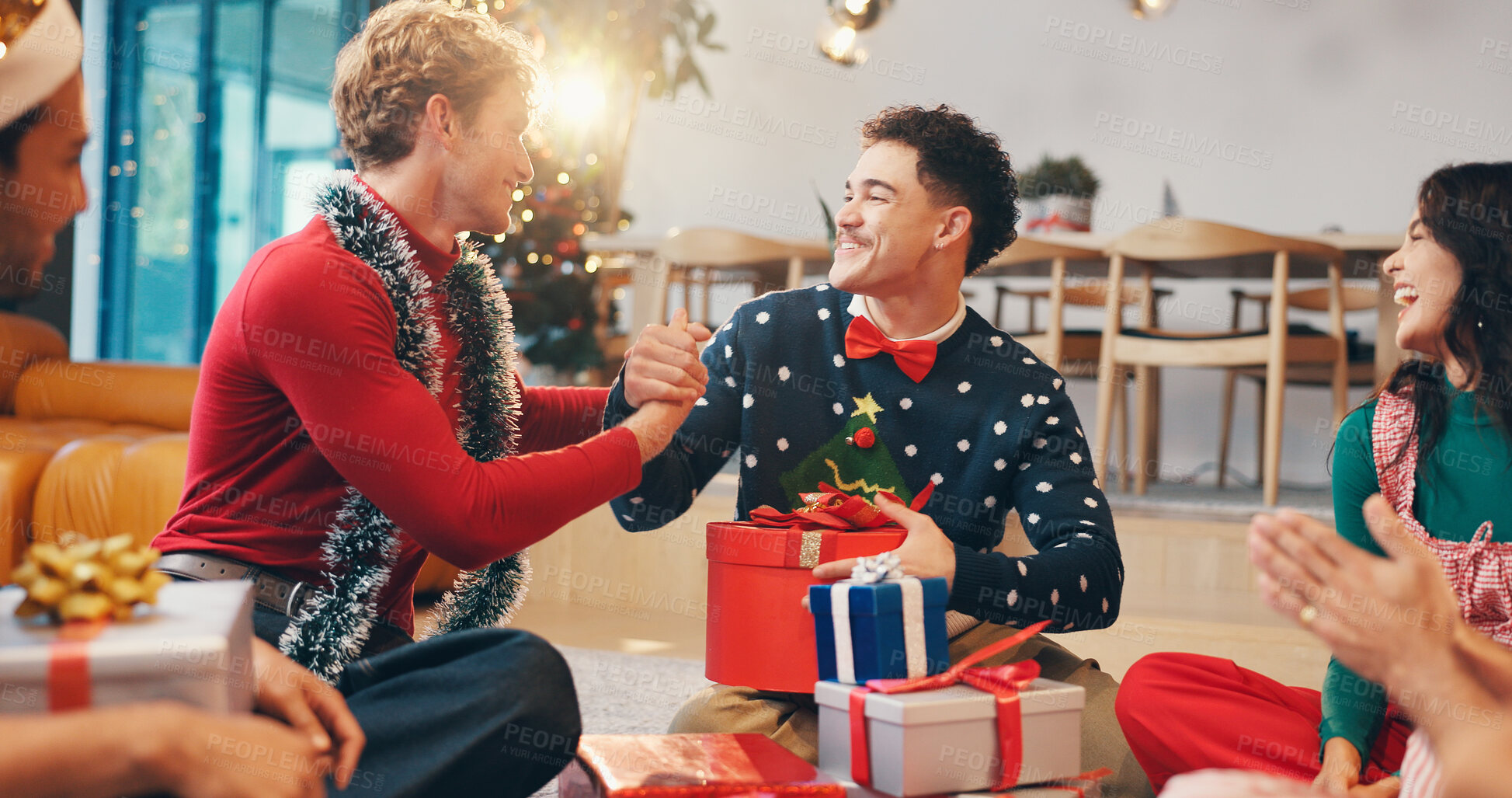 Buy stock photo Christmas, gift and thank you with friends at party for love, festive holiday and reunion. Present, support and xmas season with people and handshake in home for box, secret Santa or celebrate