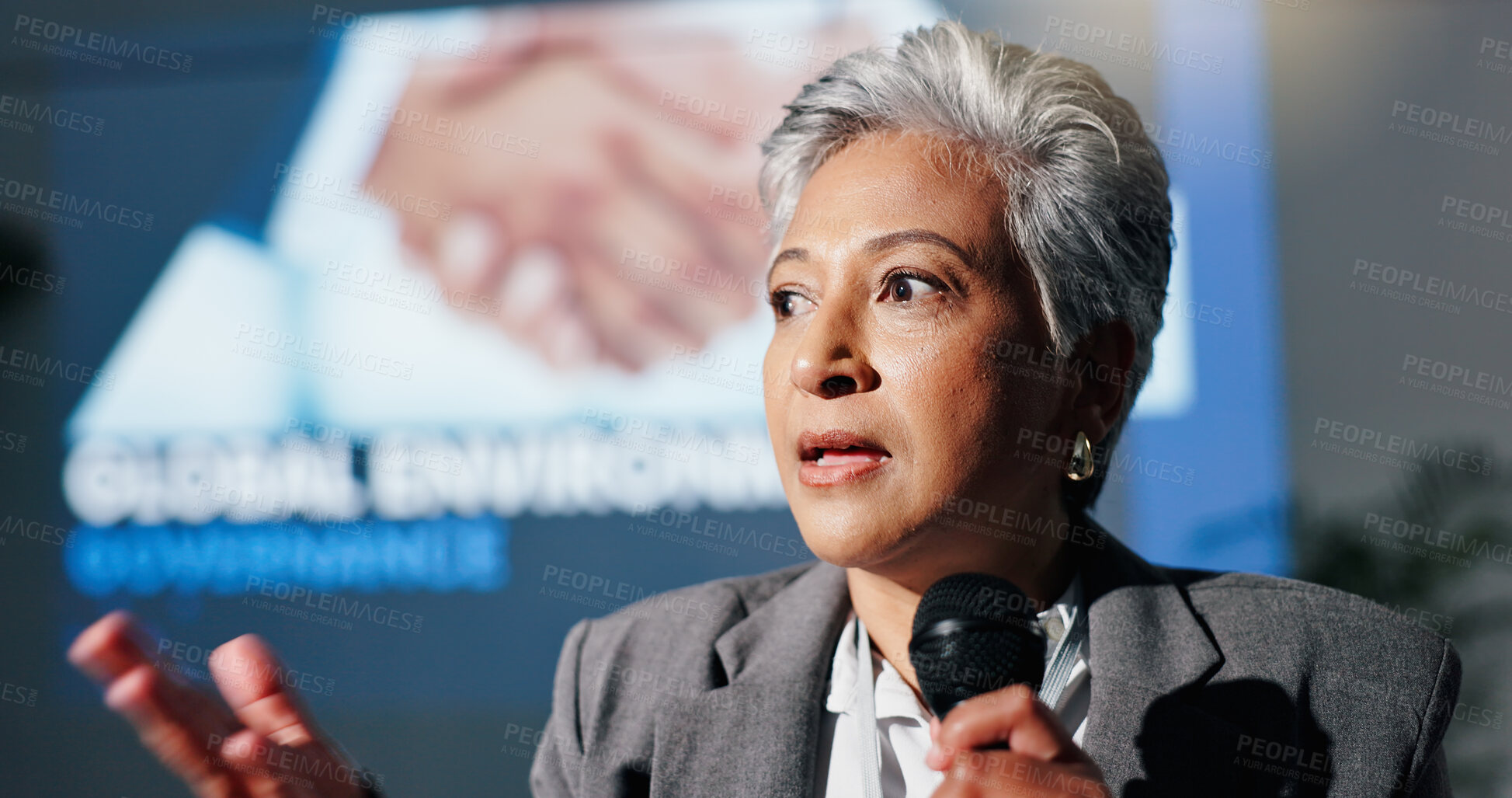 Buy stock photo Mature woman, mic and presentation for environment on stage, governance and speech at convention. Person, speaker and discussion for global sustainability, info and accountability at conference