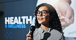 Woman, speaker and mic with speech at conference for health awareness, wellness and medical tips. Person, public speaking and healthcare seminar, pharmaceutical launch and advice to prevent illness
