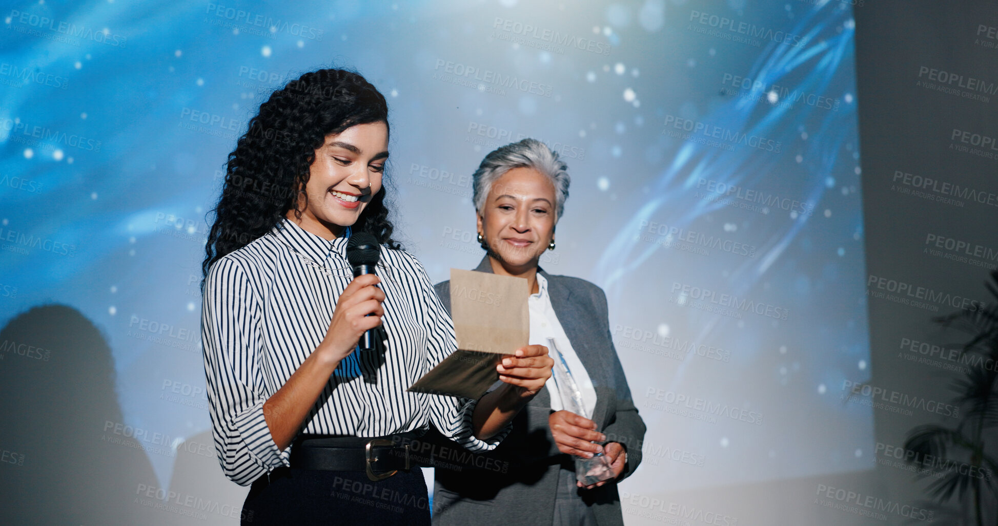 Buy stock photo Announcement, awards ceremony and presentation with business women on stage for corporate event. Microphone, prize giving and reading winner with employee people in auditorium or convention center