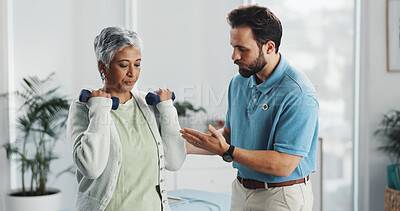 Buy stock photo Mature woman, dumbbells and physiotherapist with advice for rehabilitation, care or weight training. People, exercise and support with equipment for recovery, muscle or healing for injury at hospital