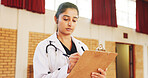 Doctor, clipboard and woman writing in community center for notes, schedule or healthcare. Medical worker, checklist and serious professional at ngo for wellness outreach, information and volunteer
