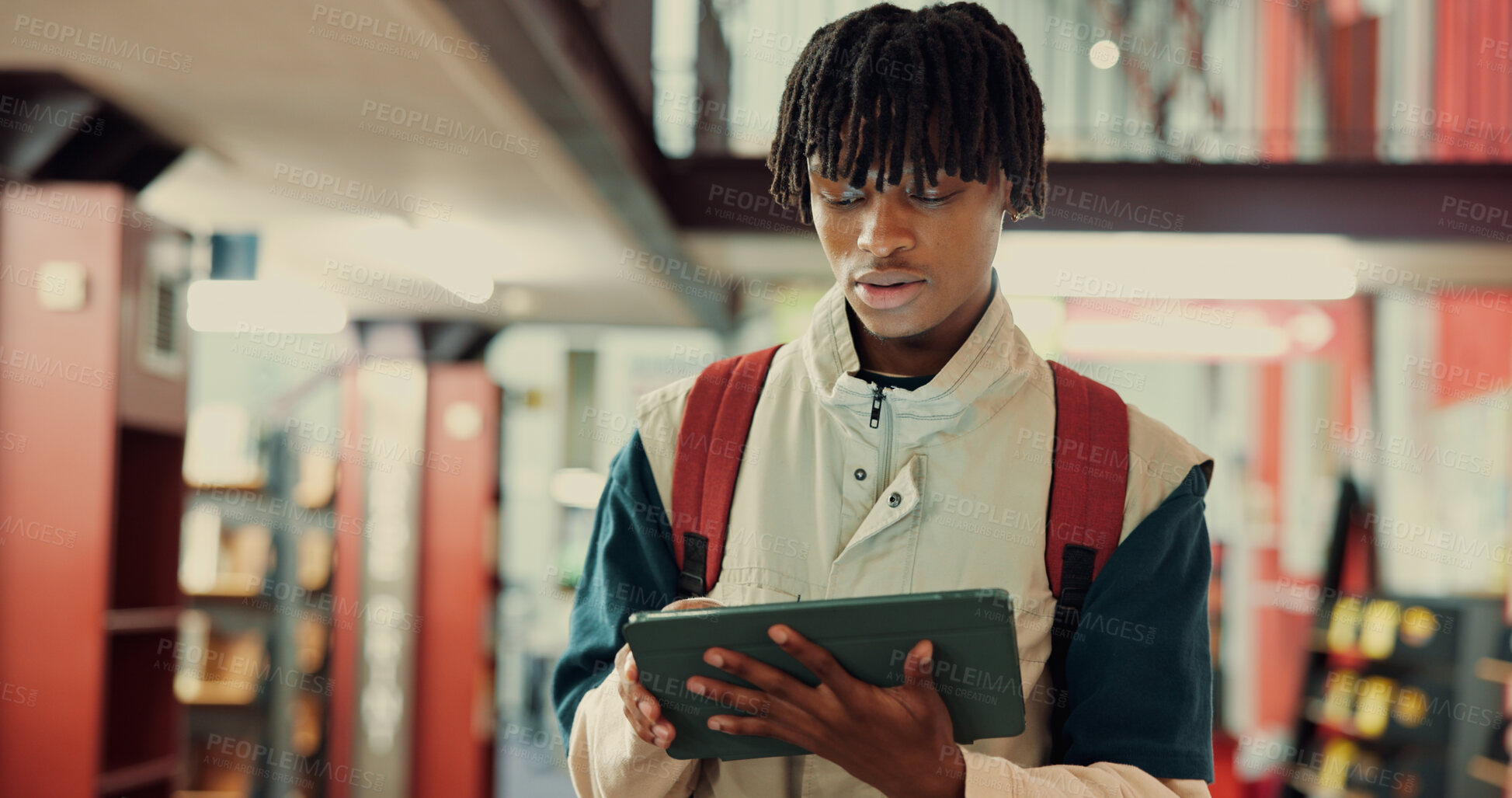 Buy stock photo Reading, research and student with tablet, library and preparing for exam, scholarship or knowledge. Serious, learner and black person with tech to study, browsing or digital info on website or space