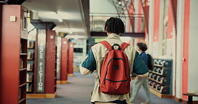 Buy stock photo Walking, college and back with student in library for learning, research project or study resource. University thesis, scholarship opportunity and knowledge with person on campus for school course