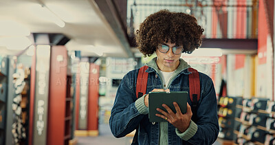 Buy stock photo Browsing, online and man with tablet, library and student with research for exam, app and knowledge. Space, serious and person with glasses for info, read and study with tech for scholarship or learn