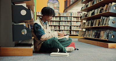 Buy stock photo Student, books and floor with black man in library for reading, assignment and college thesis. University, scholarship and education with person and bookshelf for project information and studying