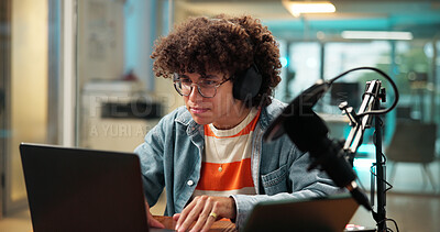 Buy stock photo Laptop, headphones and man with microphone for podcast, broadcast and radio host. Computer, reading and streamer in studio with audio equipment for editing show, production and content creation