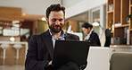 Happy, businessman and laptop at hotel for travel, work trip or communication in lounge suite. Man, employee or traveler with computer or app for online business opportunity, career or accommodation