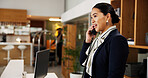 Woman, phone call and talk at hotel, concierge and happy with clerk for booking information. Person, help desk and receptionist with telephone, contact and listen with hospitality service at lodge