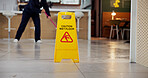 Cleaning, business and caution for wet floor, warning and person with equipment for service or sign. Board, information and notice for safety, disinfection and routine for sanitation of coffee shop