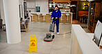 Janitor, cleaning service or polishing machine in office for scrubbing tiles, maintenance or hygiene. Cleaner, wet floor and man with equipment at work for dirt removal, surface grime or warning sign