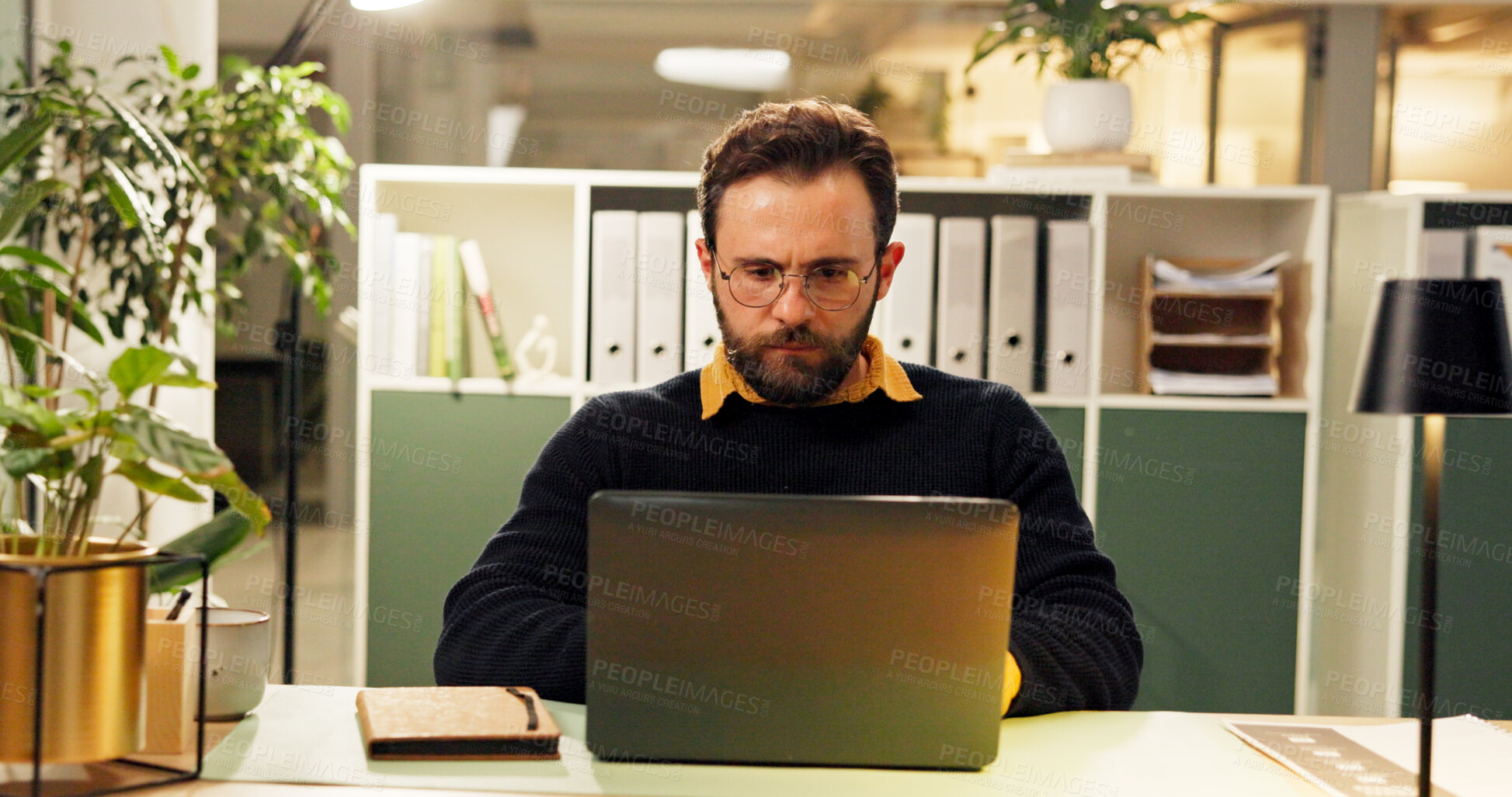 Buy stock photo Man, laptop and night at startup, research and typing for report, project and deadline in office. Person, editor and computer with reading, feedback or review process with overtime at creative agency