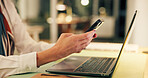 Businesswoman, hands and texting with phone by laptop for night trading, stocks account or email. Office, working late and person with smartphone for online research, portfolio review or finance news
