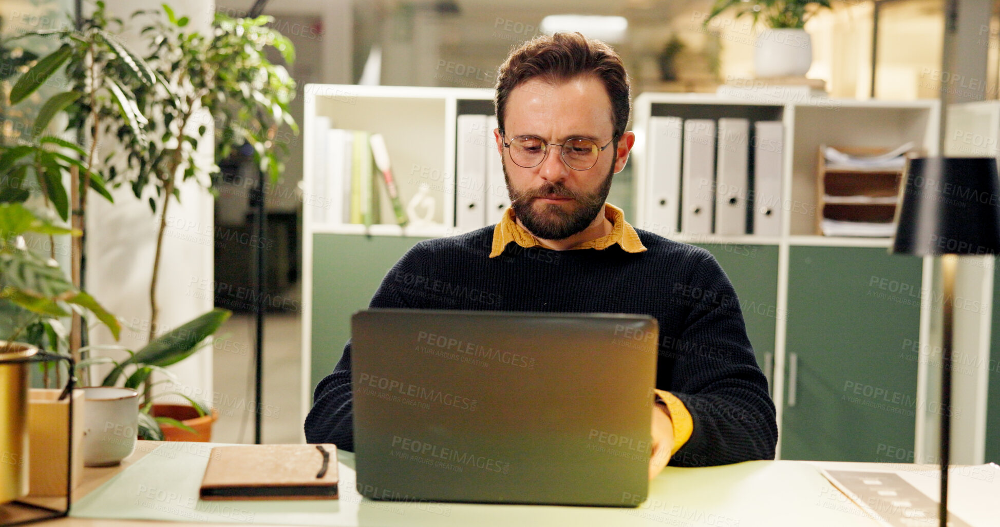 Buy stock photo Man, laptop and night at office, typing and research for report, project and deadline in startup. Person, editor and computer with reading, feedback or review process with overtime at creative agency