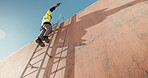 Wall, technician and low angle of man on ladder for installation, building and outdoor construction. Climb, radio or cable contractor on steps for electrical check, communication and mockup space