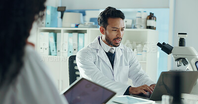 Buy stock photo Man, scientist and laptop in lab with colleague for microbiology study, report or feedback with discussion. Team, microscope and talking for medical research, pharmaceutical development and typing