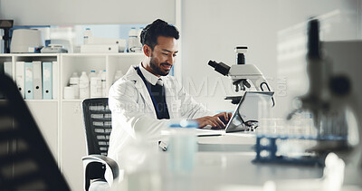 Buy stock photo Man, scientist and typing on laptop in lab for research, medical study and test feedback. Male person, smile and microscope for experiment, online results and solution report for vaccine breakthrough