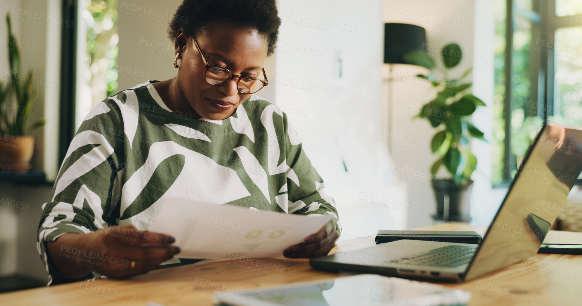Buy stock photo Reading, paperwork and woman with laptop, home and data analysis with tech, accountant or freelance. Review, financial report and black person with documents for bookkeeping, remote work and house
