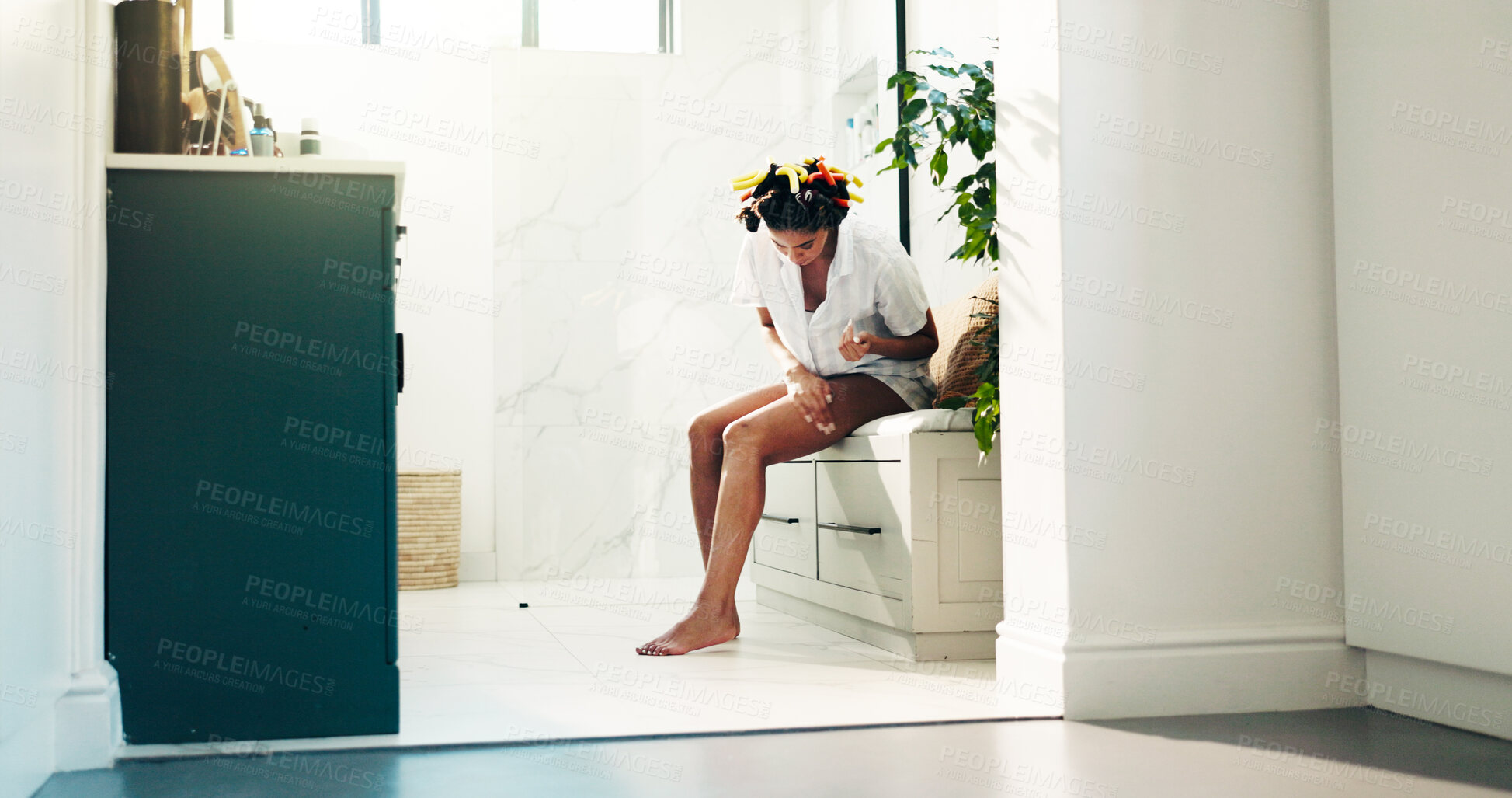 Buy stock photo Bathroom, skincare and woman with cosmetics, legs and getting ready with moisturizer or dermatology. Bodycare, self care and person with treatment for hydration, wellness and grooming in house