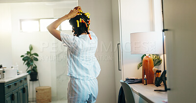 Buy stock photo Hairstyle, curls and back of woman in bathroom for self care, grooming and treatment. Beauty, pinup hair tools and DIY routine with person and curling rods in home for cosmetics, shampoo and growth