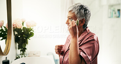 Buy stock photo Beauty, senior woman or jade roller in mirror for anti aging, eye puffiness reduction or self care. Morning, happy person and cosmetics tool in home for lymphatic drainage or undereye skin elasticity