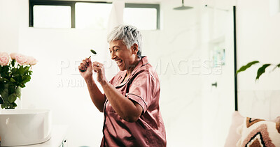 Buy stock photo Jade roller, energy and excited senior woman in bathroom for morning, skincare and routine. Beauty, singing and wellness with happy mature person in apartment for antiaging, dermatology or gua sha