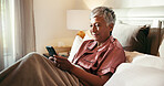 Phone, smile and senior woman in bed with dating app, social media or comedy video on internet. Happy, technology and mature female person with scroll on mobile with cellphone in home for break