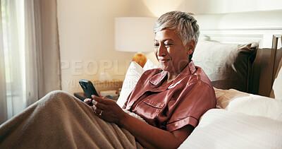 Buy stock photo Phone, smile and senior woman in bed with dating app, social media or comedy video on internet. Happy, technology and mature female person with scroll on mobile with cellphone in home for break