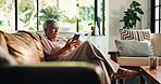 Mature woman, phone and couch in home with reading, texting and notification. Person, thinking and decision with mobile app, smartphone search and web post on social media on sofa in living room