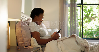 Buy stock photo Reading, phone and smile with black woman in bedroom for chat, notification and morning routine. Relax, social media and wellness with person in home for contact, typing and online news update