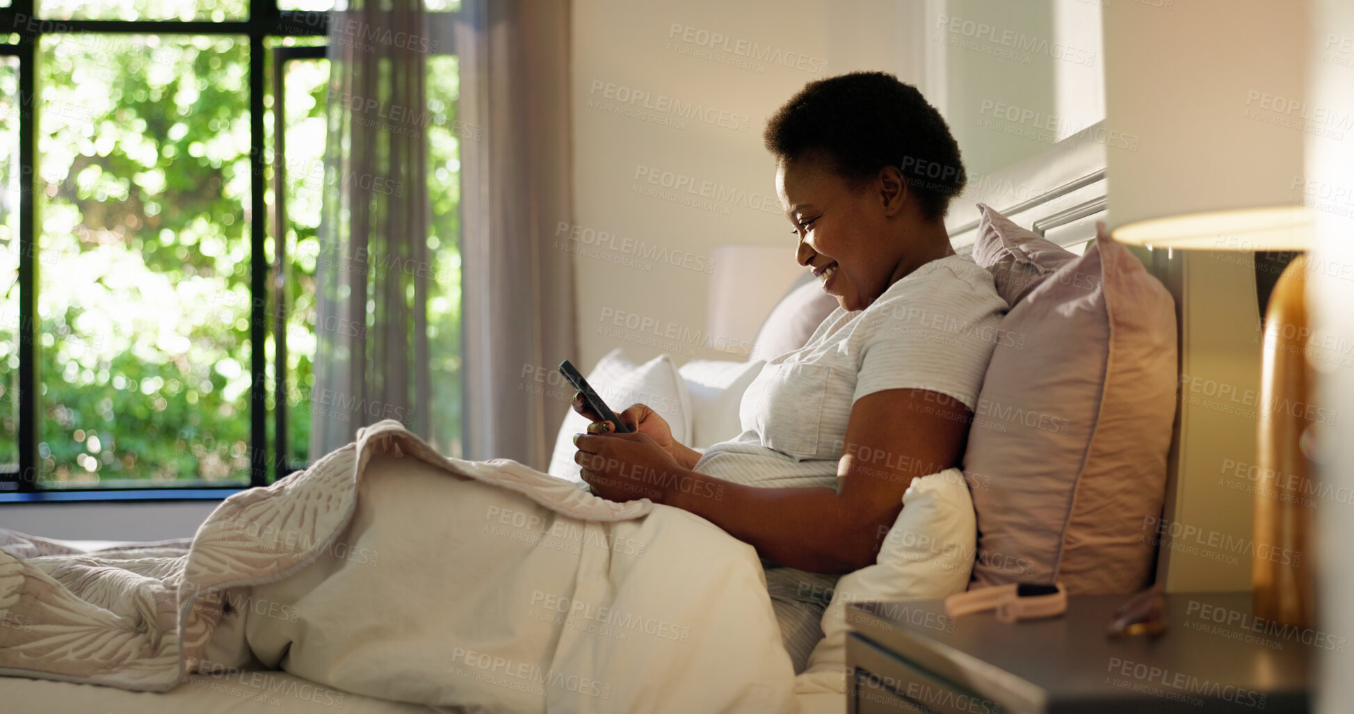 Buy stock photo Reading, phone and texting with black woman in bedroom for chat, notification and morning routine. Relax, social media and wellness with person in home for contact, typing and online news update
