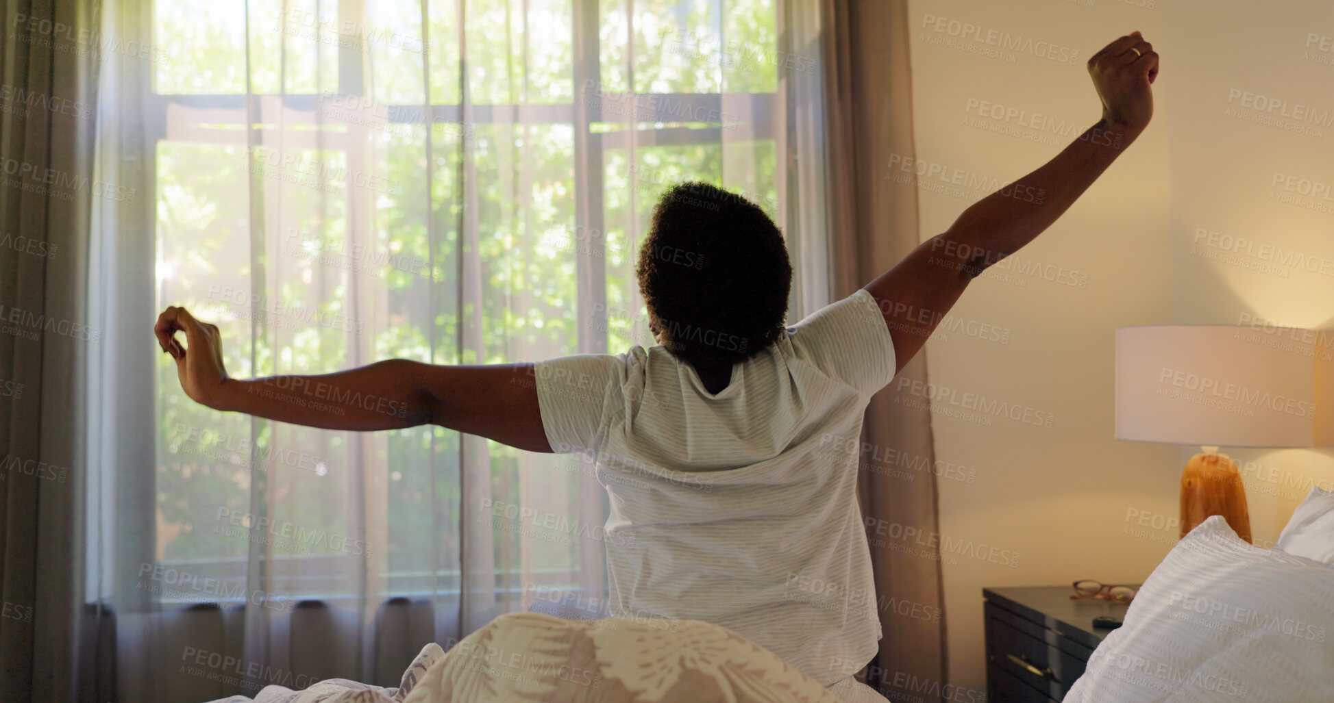 Buy stock photo House, back view and black woman stretching in bed for health, wellness or resting routine in morning. Curtains, relax and person waking up lazy in apartment with comfort, pyjamas and calm with peace