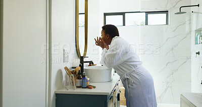 Buy stock photo Black woman, makeup and morning by bathroom mirror, home or product for beauty with dermatology. African person, skincare and cosmetics in profile with touch for results, routine or wellness in house
