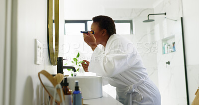 Buy stock photo Black woman, makeup brush and beauty in bathroom, home and mirror for application with morning routine. African person, tools and cosmetics with grooming for change, powder and foundation in house