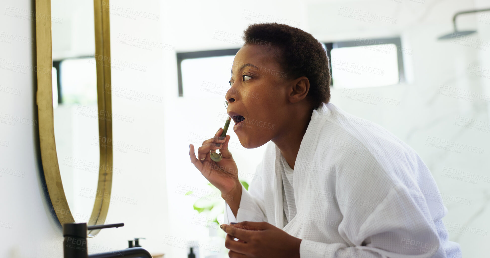Buy stock photo Home, jade roller and black woman with mirror, bathroom and dermatology with healthy skin. African person, apartment or morning routine with cosmetics, wellness and beauty with skincare or anti aging