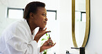 Black woman, jade roller and skincare by bathroom mirror in home with smile, circulation or results. African person, happy and beauty with tools with touch, transformation and dermatology in morning