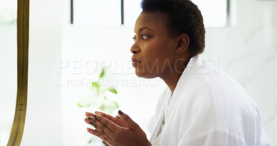 Buy stock photo Grooming, routine and woman with mirror, bathroom and cosmetics for smooth skin, think and skincare. Home, serious and black person with moisturizer for facial treatment, dermatology and self care