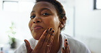 Facial treatment, skincare and woman with cosmetics, grooming and routine for smooth skin or beauty. Home, black person and dermatology for soft face, moisturizer and self care in morning or bathroom