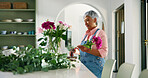 Old woman, florist and flowers in vase at house of special occasion, aesthetic and natural bloom. Senior person, arrangement and plant care of floral bouquet, hospitality decoration and resort setup
