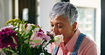 Smile, home and senior woman with flowers, bouquet present and floral aroma. Pensioner, apartment and elderly person with gift, natural and relax with plants, retirement and hobby with happiness