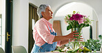 Elderly woman, flowers and vase at house for special occasion, aesthetic and natural bloom. Senior person, arrangement and plant care with floral bouquet, hospitality decoration and beauty in lounge