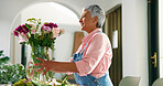 Senior woman, flowers and vase at house for special occasion, aesthetic and natural bloom. Elderly person, arrangement and plant care with floral bouquet, hospitality decoration and beauty in lounge