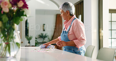 Buy stock photo Mature woman, cleaning and wipe table in home for housekeeping, chores or hygiene maintenance. Daily housework, person and disinfect surface with cloth for flower petals, dirt and leaves in house