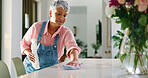 Senior woman, spring cleaning and wipe surface for hygiene, chores and housekeeping in home. Housework, person and table disinfection with cloth for bacteria, virus and germ prevention in retirement